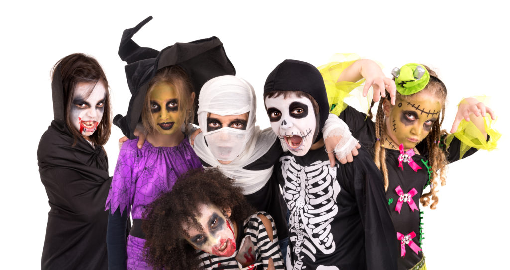 Barn med ansiktetsmaling og Halloween-kostymer
